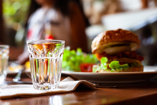 Copos de coquetel vazios na mesa com hambúrguer no restaurante