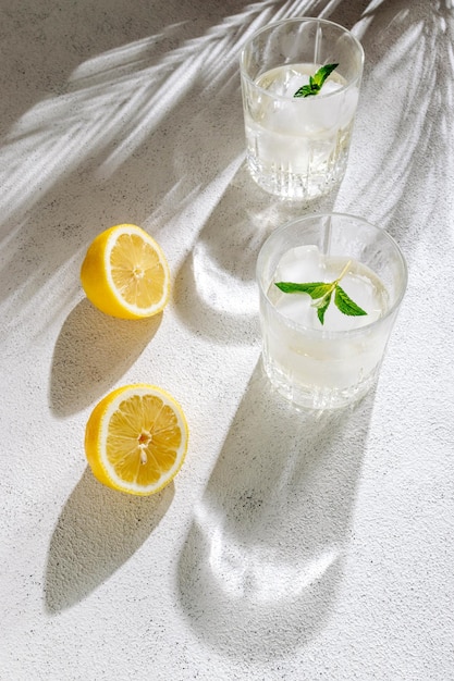 Copos de cristal com limonada cítrica caseira fresca com gelo e folhas de hortelã Bebida refrescante de verão