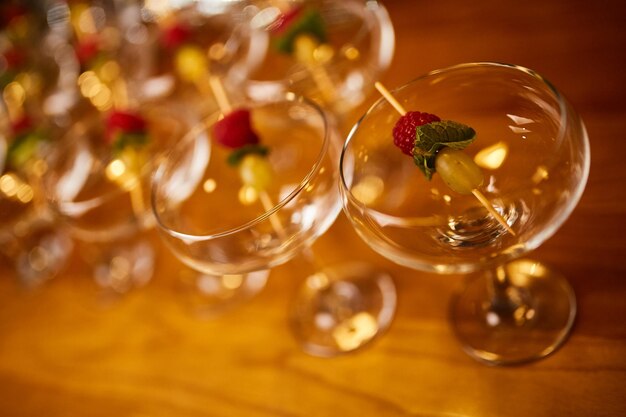 Copos de martini ficam em um suporte de madeira Copos de martini estão no bar copos limpos com álcool