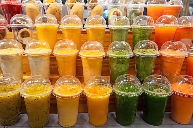 copos de plástico coloridos com suco de frutas e bagas no mercado