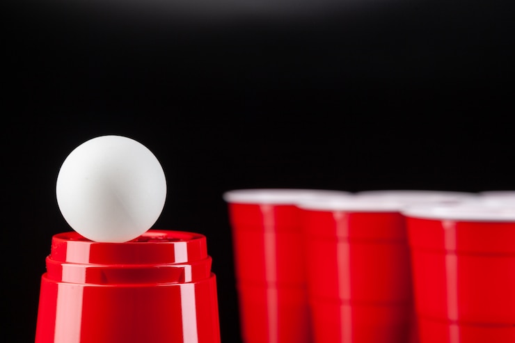Foto copos de plástico vermelhos e bola para o jogo de pong de cerveja