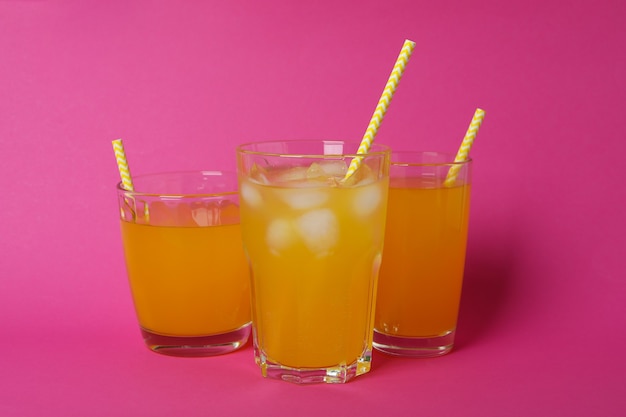 Copos de refrigerante de laranja na superfície rosa