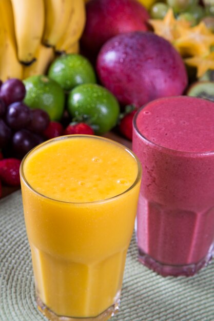 Foto copos de suco com frutas frescas para o verão.