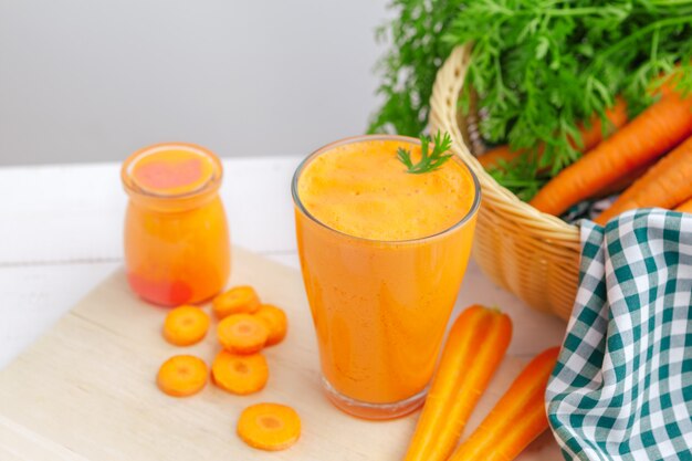 Copos de suco de cenoura com legumes na mesa close-up