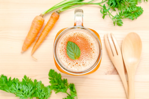 Copos de suco de cenoura com raízes de cenoura.