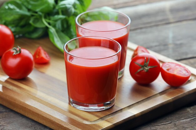 Copos de suco de tomate na mesa de madeira closeup