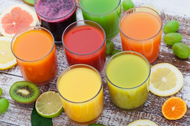 Copos de suco fresco saboroso, na mesa de madeira.