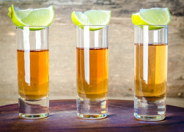 Copos de tequila na tábua de madeira