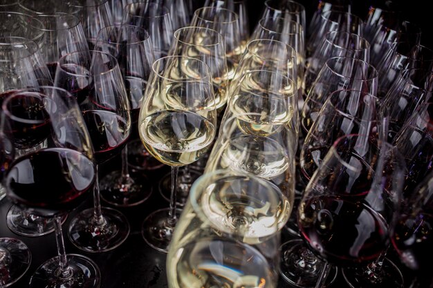 Copos de vinho branco no balcão de bar pequena profundidade de foco Muitos copos de vinho branco e tinto