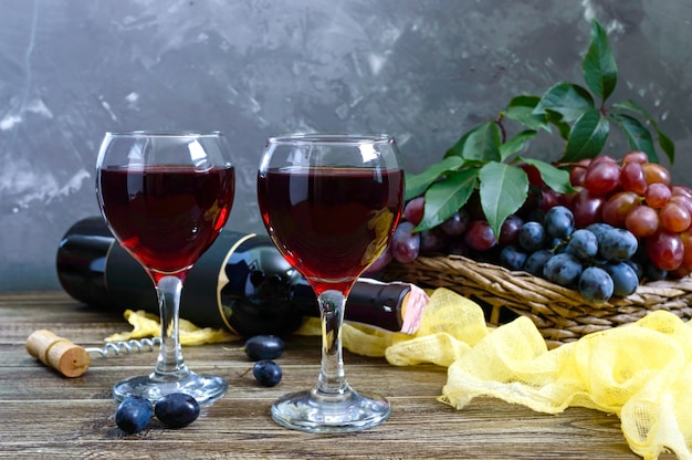 Copos de vinho com vinho tinto, garrafa e uvas frescas