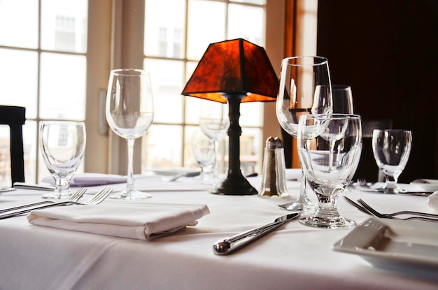 Copos de vinho e lâmpada na mesa do restaurante