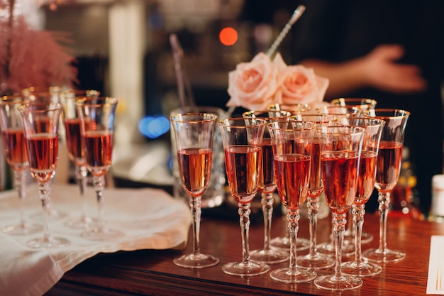 Copos de vinho espumante rosa na mesa do bar.