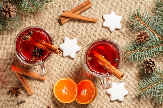 Copos de vinho quente de Natal com especiarias e laranja em pano de saco