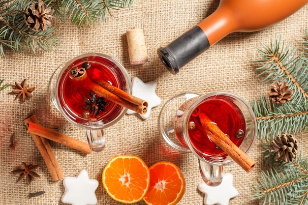 Copos de vinho quente de natal com especiarias e laranja em pano de saco