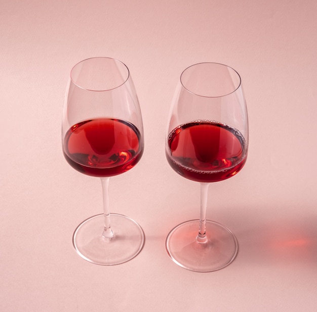 Copos de vinho tinto na mesa-de-rosa, vista superior.