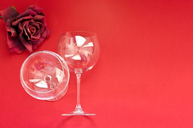 Foto copos de vinho vazios sobre um fundo vermelho conceito de dia dos namorados