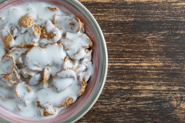 Copos glaseados de grano entero con yogur en plato Desayuno saludable muesli de grano entero en un bol