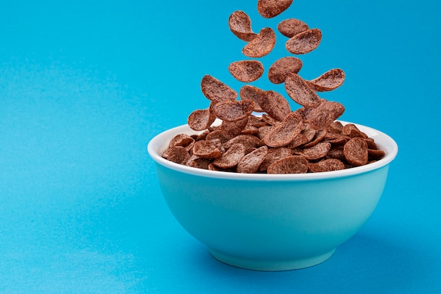 Foto copos de maíz de chocolate cayendo, desayuno de cereales saludable