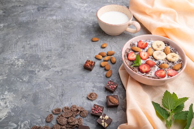 Copos de maíz de chocolate con leche, fresa y almendras en cuenco de cerámica