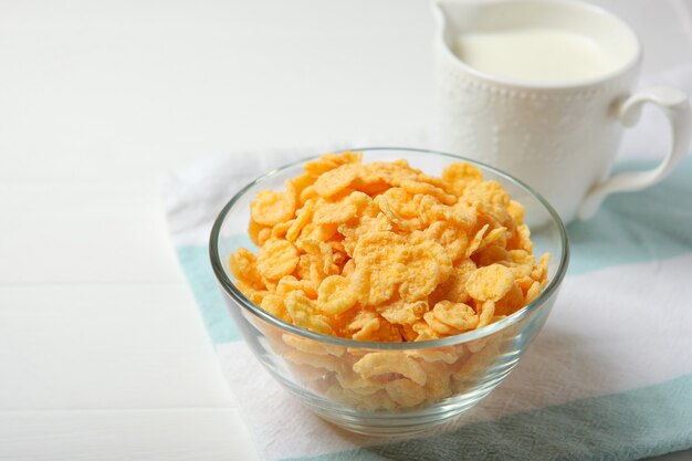 Copos de maíz crujientes con leche para el desayuno en el primer plano de la mesa