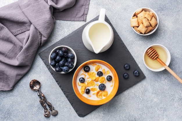 Copos de maíz hechos de cereales naturales con arándanos frescos, miel y leche