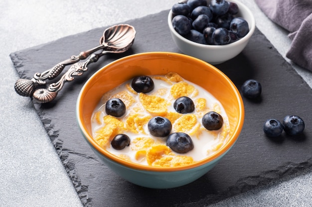 Copos de maíz hechos de cereales naturales con arándanos frescos, miel y leche