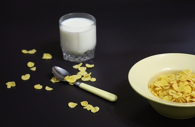 Copos de maíz en un plato. Desayuno de copos con miel y leche. Desayuno rápido con copos de maíz