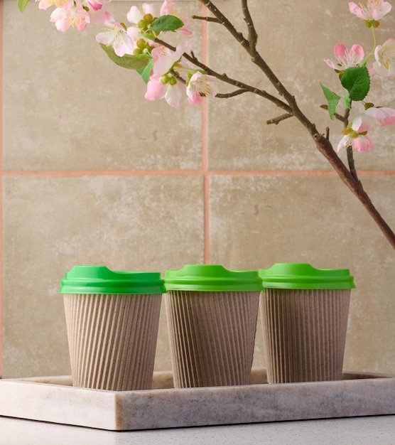 Copos marrons de papel com tampa de plástico verde para café e chá