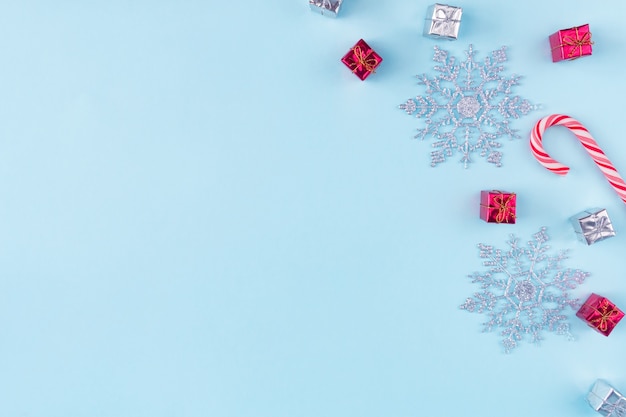 Copos de nieve y cajas de regalo aisladas en azul