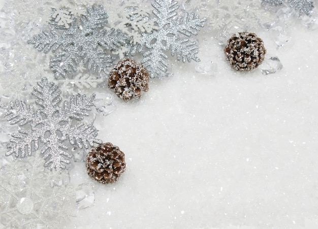 Copos de nieve de Navidad y conos de pino enclavado en la nieve