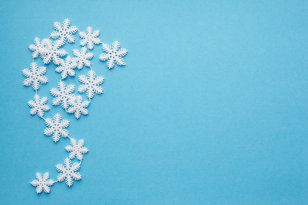 Los copos de nieve sobre un fondo azul con lugar para el texto.