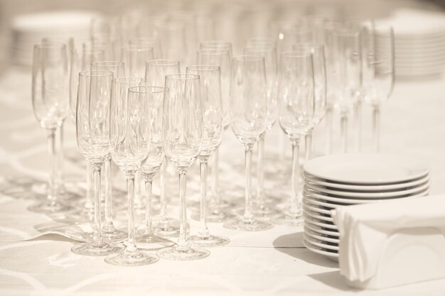 Copos para vinho e pratos vazios na mesa pelo serviço de catering