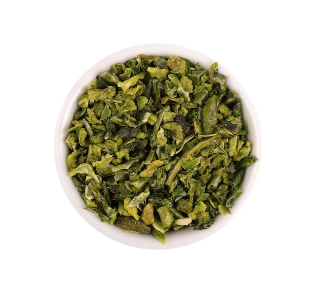 Copos de pimentón verde seco con semillas en un tazón, aislado sobre fondo blanco. Chile jalapeño, habanero o guindilla picado. Especias y hierbas. Vista superior.