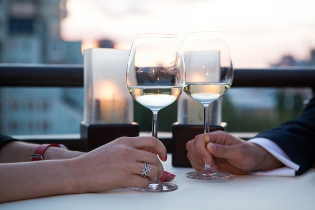 Copos tilintando com vinho branco e torradas.