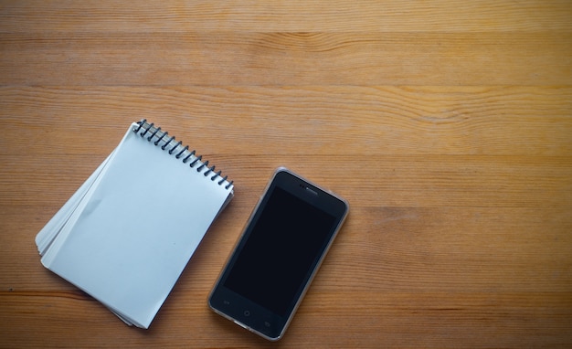 Coppy espacio en la mesa de trabajo de negocios con teléfono inteligente y organización, concepto de fondo de escritorio de oficina