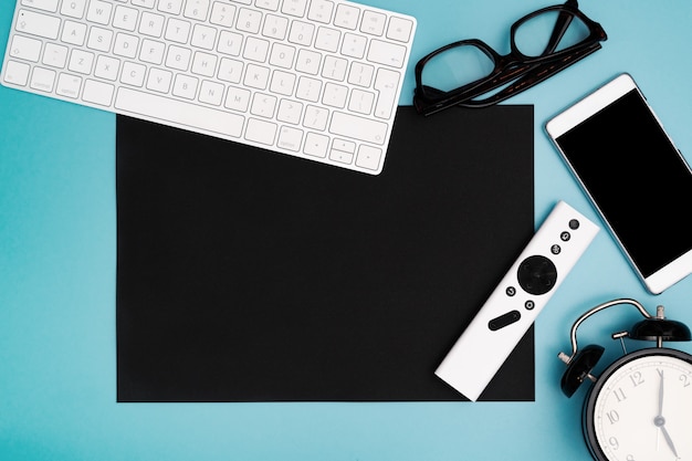 Copyspace de papel preto com teclado de computador, vidros, smartphone e pulso de disparo. topview, espaço de cópia