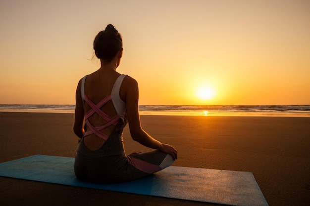 Copyspace-Frau, die Yoga macht, Asanas durchführt und das Leben bei Sonnenuntergang am Strand-Meer-Kopierraum genießt