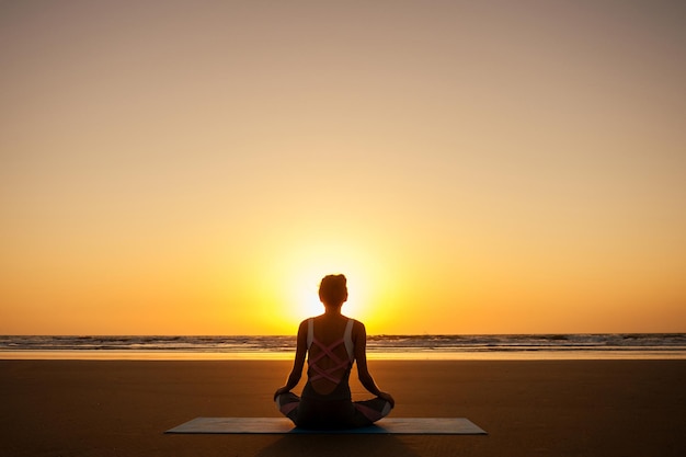 Copyspace mujer haciendo yoga realizando asanas y disfrutando de la vida al atardecer en el espacio de copia de mar de playa