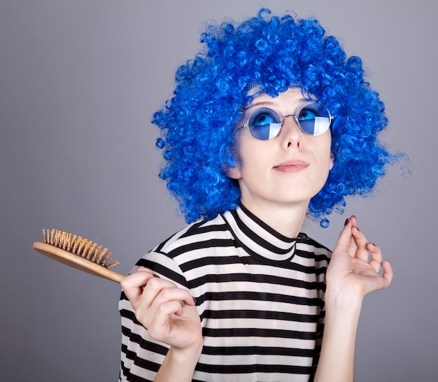 Coqueta chica de pelo azul con peine.