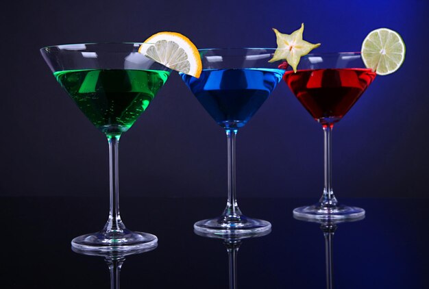 Coquetéis alcoólicos em copos de martini em fundo azul escuro