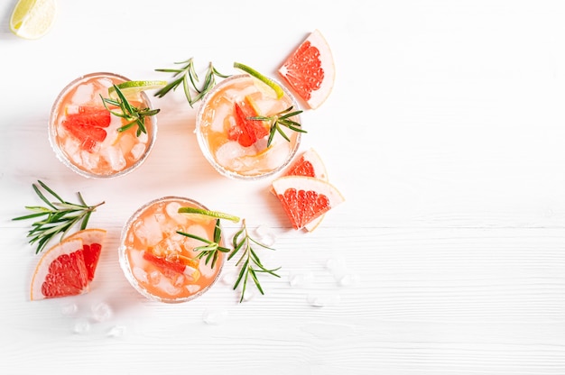 Coquetéis alcoólicos Paloma com tequila e gelo guarnecidos com fatias de limão e grapefruit