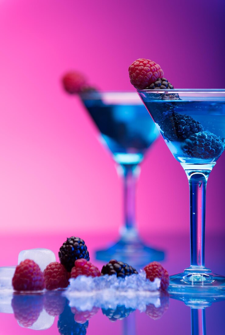 Foto coquetéis coloridos adornados com bagas em estúdio com fundo cor-de-rosa e roxo