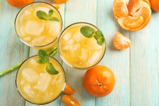 Coquetéis frescos com hortelã gelada e tangerinas na vista superior da mesa de madeira