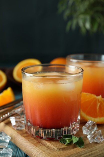 Coquetéis Tequila Sunrise e ingredientes na mesa de madeira