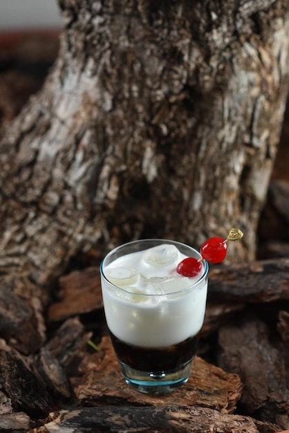 Coquetel à base de vodka e café com creme branco russo no fundo da casca de árvore