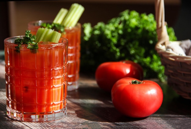 Coquetel Bloody Mary com cubos de gelo, palitos de aipo e salsa. Suco de tomate. Rústico. Fechar-se