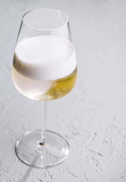 Foto coquetel branco com espuma num copo de vinho