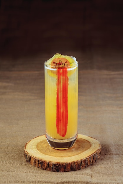 Coquetel brilhante em um suporte de madeira. Refrigerante de bebida alcoólica.