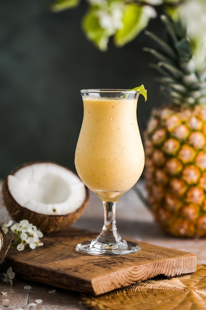 Coquetel de abacaxi Pina colada ou Lassi em uma mesa de madeira rústica