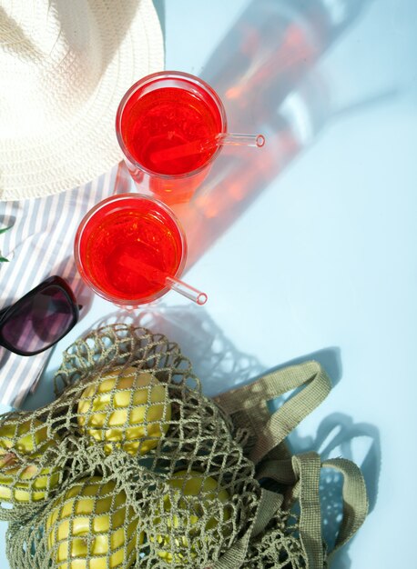 Coquetel de bebida refrescante de verão em um piquenique com maçãs verdes em uma bolsa de rede, óculos escuros e chapéu.